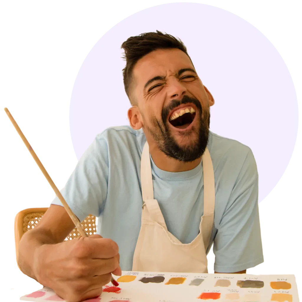 A disabled man smiling while painting