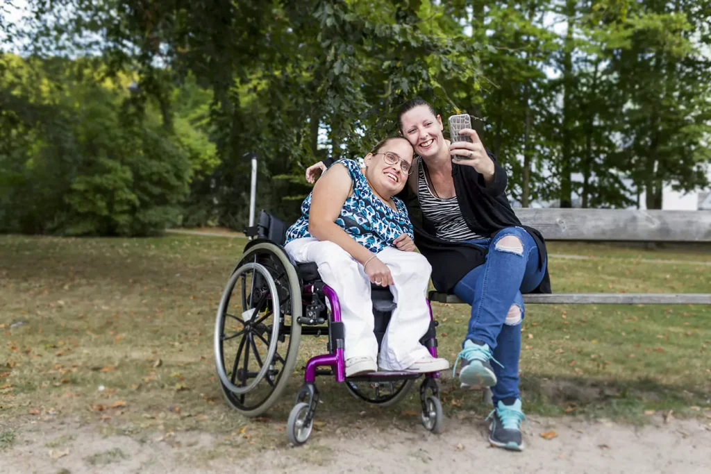 A disabled woman in her wheelchair and her support worker