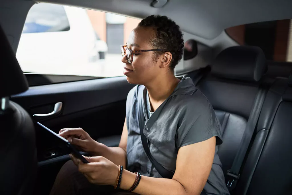 A woman using a tablet inside the car